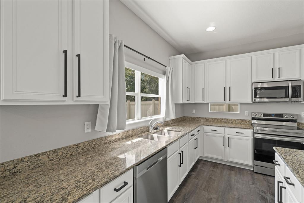 10909 Observatory Way Tampa, FL 33647 - Photo 13 of 39 a kitchen with granite countertop a sink stainless steel appliances and white cabinets