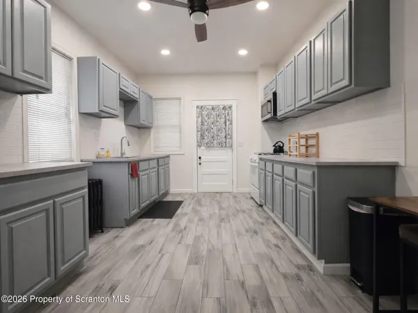 a kitchen with stainless steel appliances granite countertop a sink stove and wooden cabinets