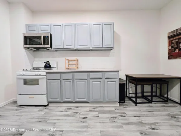 a kitchen with stainless steel appliances granite countertop a white cabinets and a stove top oven