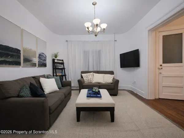 a living room with furniture a flat screen tv and kitchen view