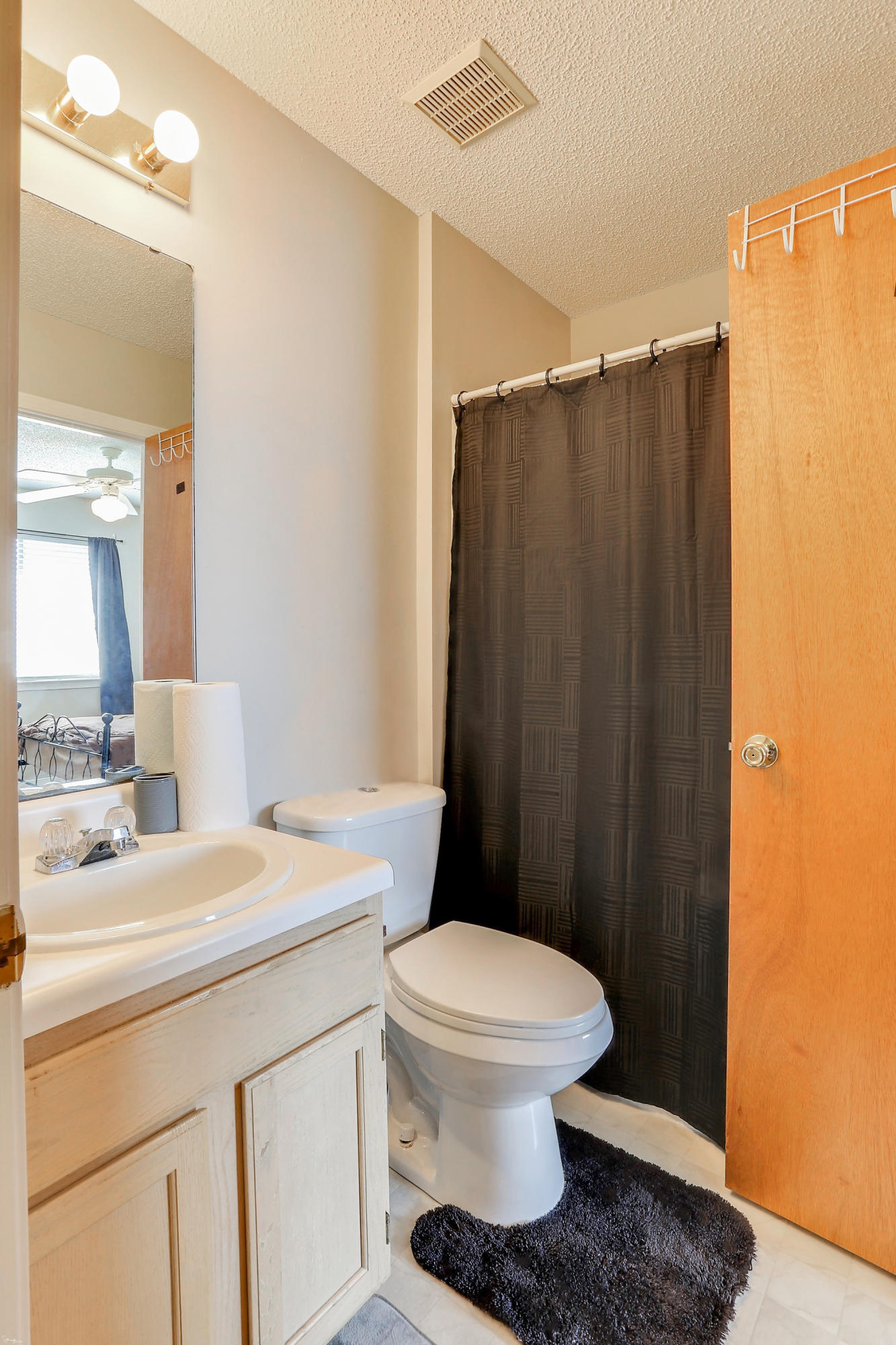 9 Falcon Ridge Lane, Unit 9 Fort Walton Beach, FL 32547 - Photo 18 of 23 a bathroom with a sink a toilet a mirror and shower curtain