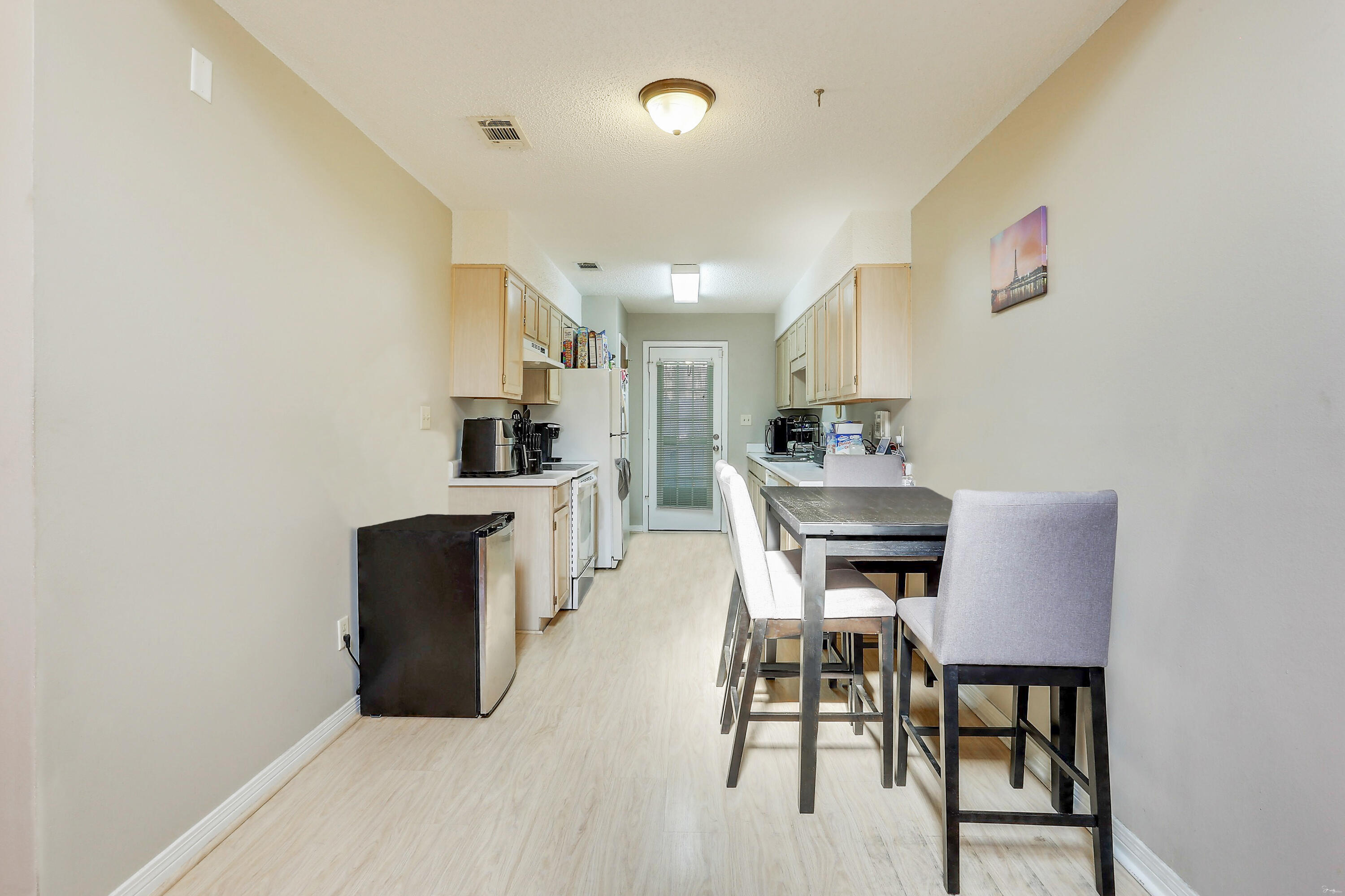 9 Falcon Ridge Lane, Unit 9 Fort Walton Beach, FL 32547 - Photo 6 of 23 a kitchen with a dining table chairs and refrigerator