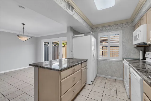 a kitchen with stainless steel appliances kitchen island granite countertop a sink stove and cabinets