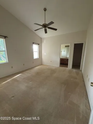 a view of a livingroom with a ceiling fan and window