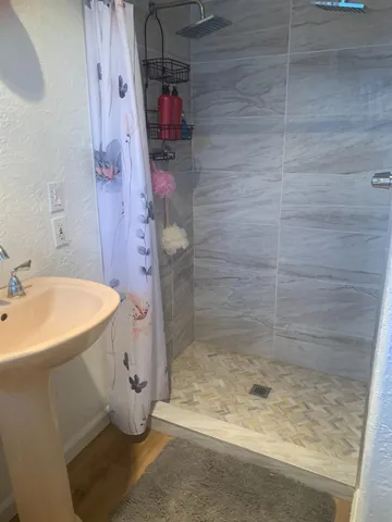 a kitchen with stainless steel appliances a refrigerator a sink a stove top oven a wooden floor and cabinets