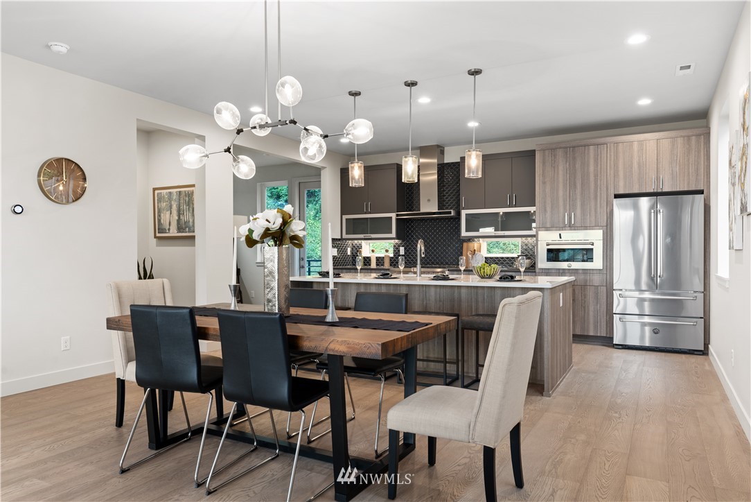 4558 22nd Avenue Southwest Seattle, WA 98106 - Photo 17 of 38 a dining room filled chandelier and kitchen view