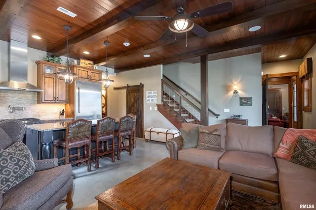 a kitchen with stainless steel appliances granite countertop a refrigerator a stove and a sink with wooden cabinets