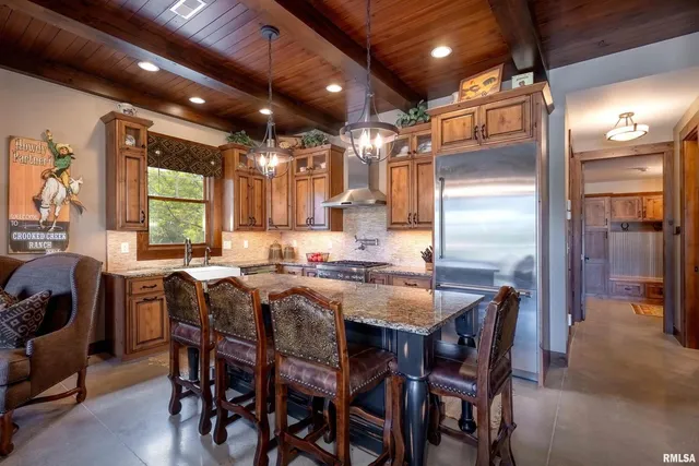 a kitchen with kitchen island granite countertop a sink stainless steel appliances and cabinets