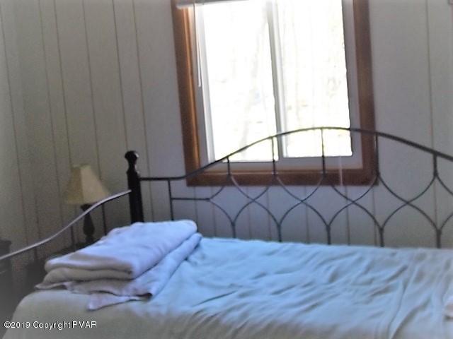 387 Ridge Road Pocono Lake, PA 18347 - Photo 11 of 14 a bedroom with a bed and a wooden floor