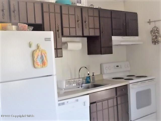 387 Ridge Road Pocono Lake, PA 18347 - Photo 6 of 14 a kitchen with stainless steel appliances a refrigerator a sink a stove and white cabinets