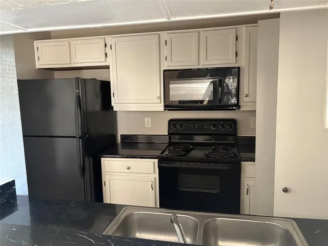 a view of an empty room with wooden floor and cabinet