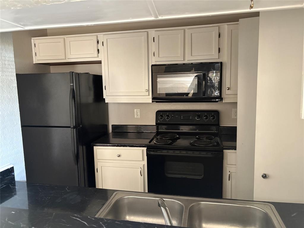 1733 Crest Grove Drive Arlington, TX 76012 - Photo 2 of 8 a kitchen with white cabinets and stainless steel appliances