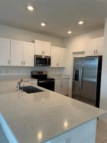 a kitchen with a refrigerator a microwave a sink and cabinets