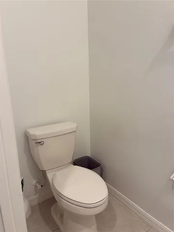 a white toilet sitting next to a white wall