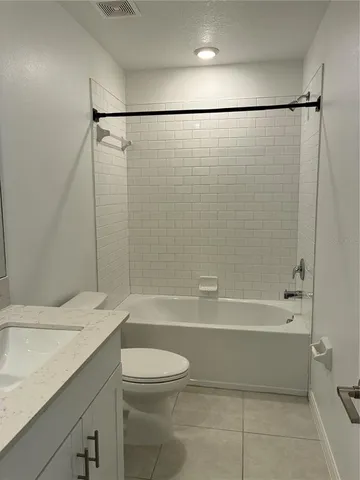 a bathroom with a granite countertop sink mirror toilet and bathtub