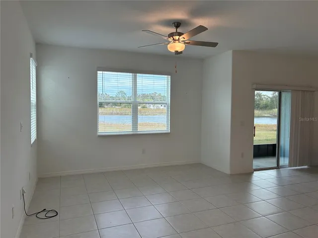 an empty room with windows and fan