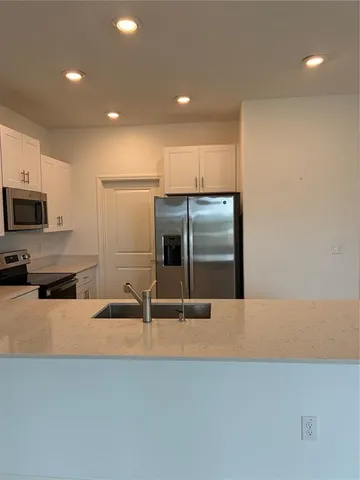 a kitchen with stainless steel appliances a refrigerator sink and microwave
