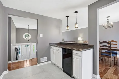a kitchen with granite countertop a refrigerator stove top oven and sink