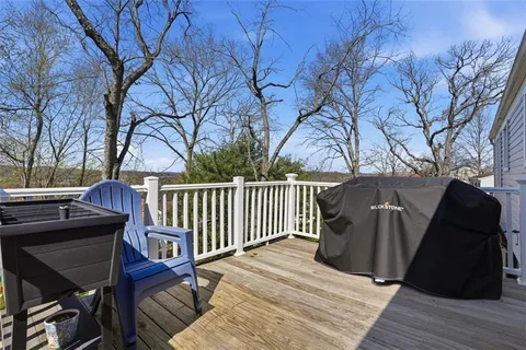 a balcony with wooden floor table and chairs