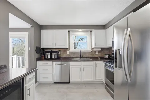 a kitchen with stainless steel appliances a refrigerator sink and microwave
