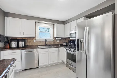 a kitchen with stainless steel appliances granite countertop a sink a stove and a microwave