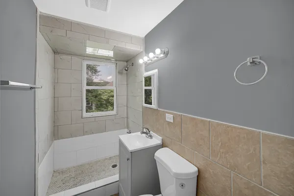 a bathroom with a sink a toilet and shower
