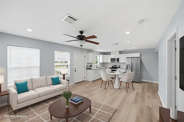 a living room with furniture and a wooden floor