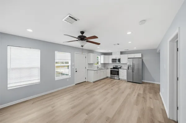 a view of a kitchen with microwave and windows