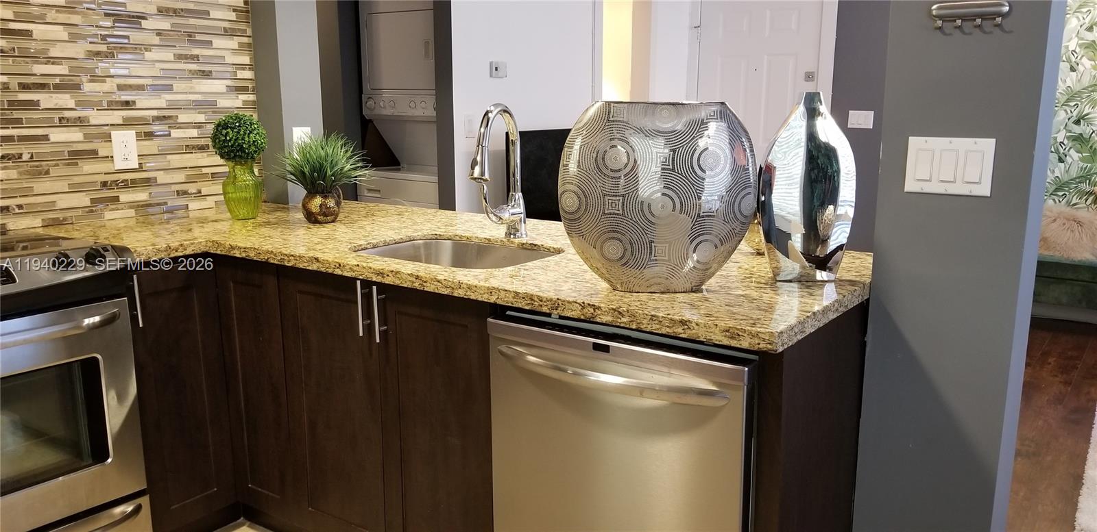 1337 Euclid Avenue, Unit 101 Miami Beach, FL 33139 - Photo 25 of 65 a kitchen with granite countertop a sink and cabinets