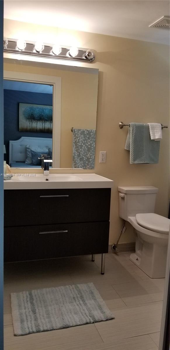 1337 Euclid Avenue, Unit 101 Miami Beach, FL 33139 - Photo 53 of 65 a bathroom with a toilet a sink and mirror