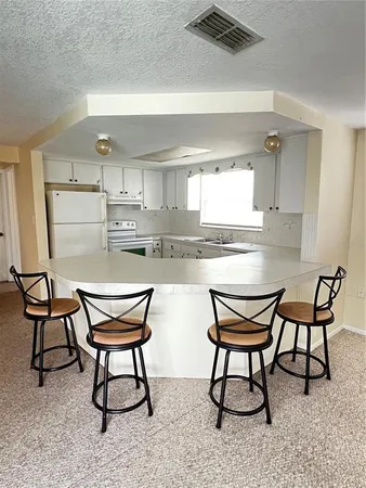 a kitchen with stainless steel appliances kitchen island a table and chair in it