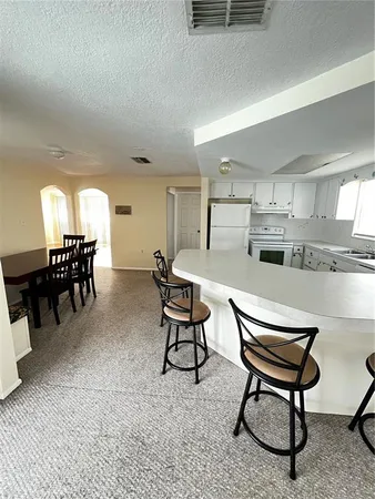 a living room with furniture a dining table and kitchen view