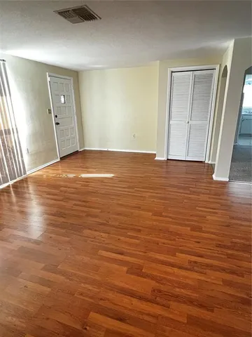 a view of empty room with wooden floor
