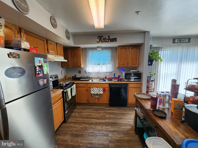 a kitchen with granite countertop a sink appliances wooden cabinets and counter space
