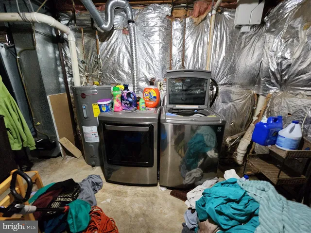a utility room with lots of clutter and cabinets