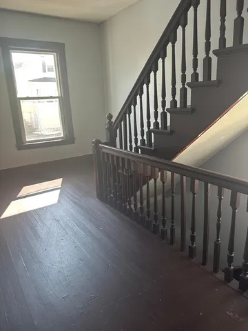 a view of staircase with railing and white walls