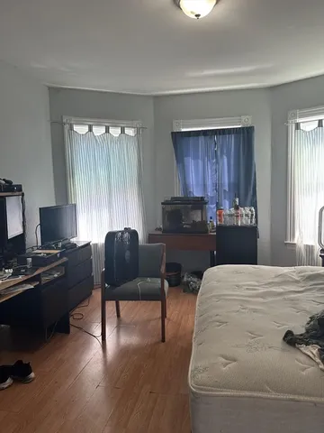 a bedroom with a bed and wooden floor