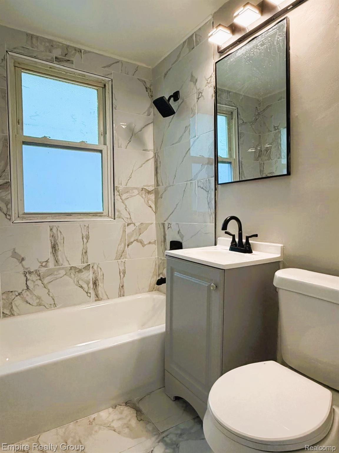 6441 Appoline Street, Unit 1 Dearborn, MI 48126 - Photo 7 of 13 Full bath with light marble finish floors, vanity, and a combined bath / shower with marble appearance