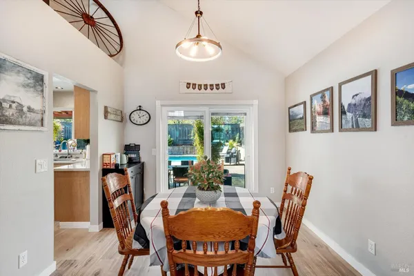 a living room with furniture a chandelier and kitchen view