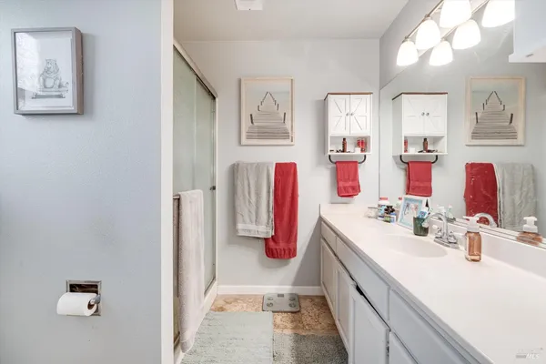 a bathroom with a sink a toilet and shower