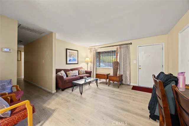 a living room with furniture a flat screen tv and a window