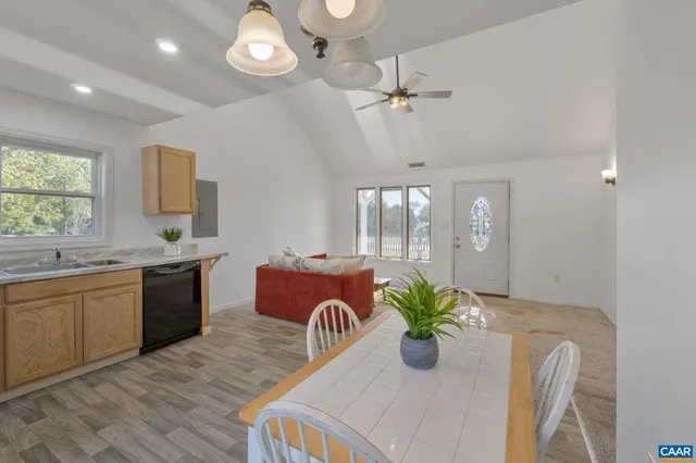 a kitchen with stainless steel appliances granite countertop wooden floor a stove a sink a dining table and chairs