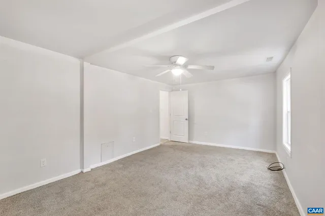 a view of an empty room with a chandelier fan