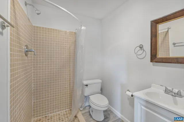 a bathroom with a toilet sink vanity and mirror