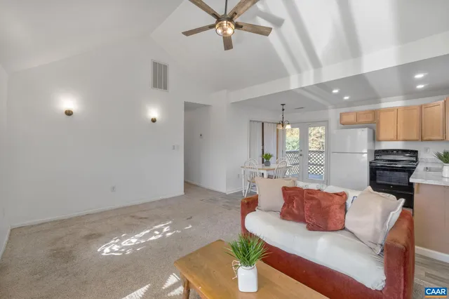 a living room with furniture and kitchen view