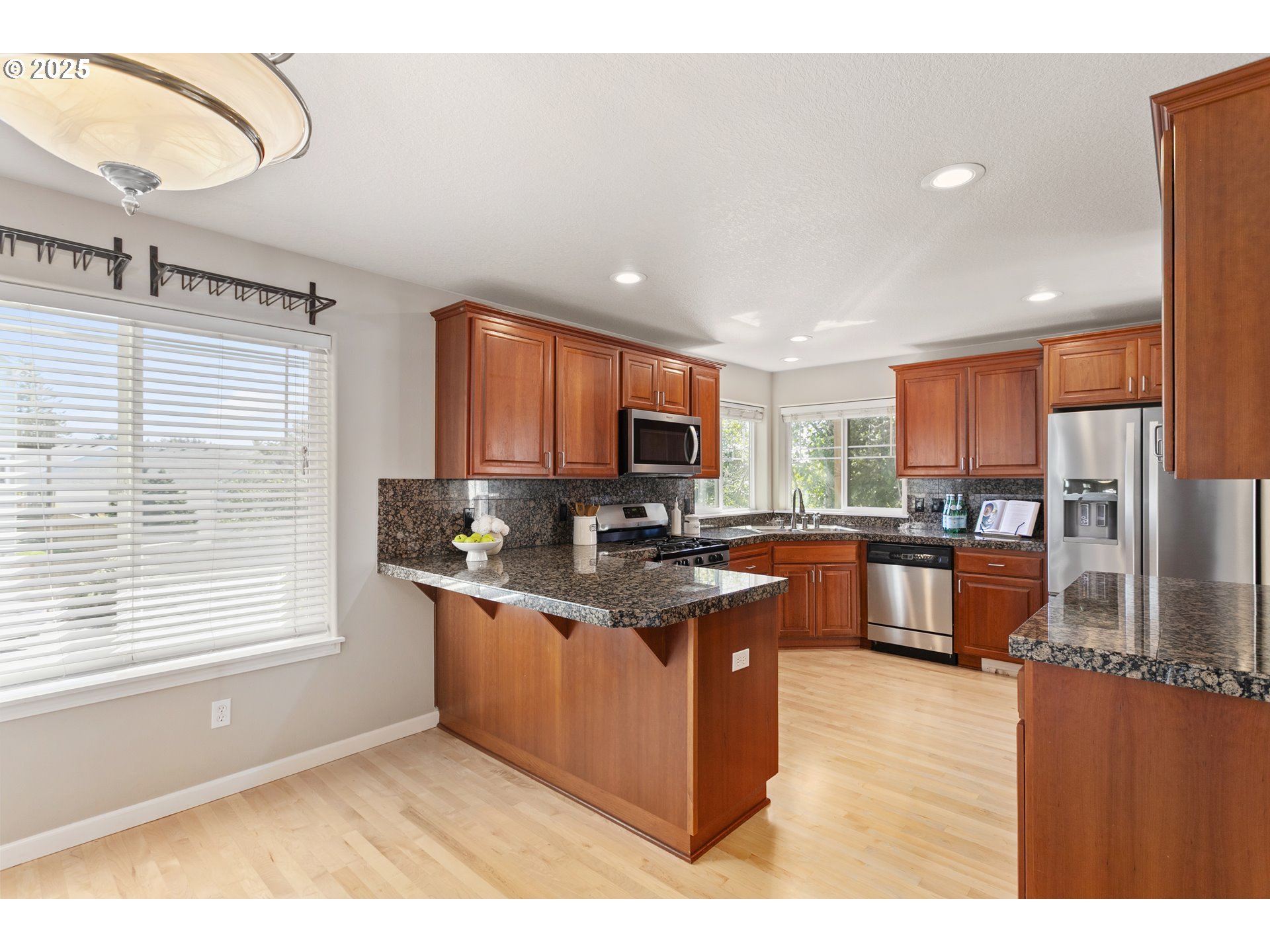 3200 Wild Rose Loop West Linn, OR 97068 - Photo 19 of 47 a kitchen with stainless steel appliances granite countertop a stove a sink dishwasher a microwave oven and a refrigerator with wooden floor
