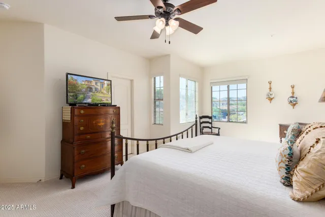 a bedroom with a bed a chandelier and a large mirror