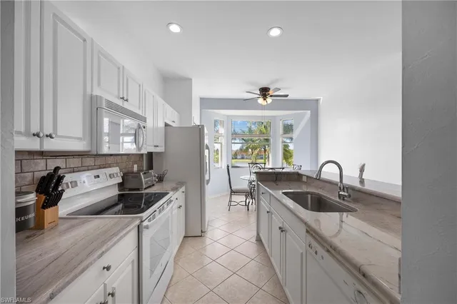 a kitchen with stainless steel appliances granite countertop a sink stove and cabinets