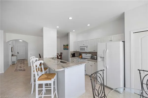 a kitchen with stainless steel appliances granite countertop a refrigerator and a stove top oven