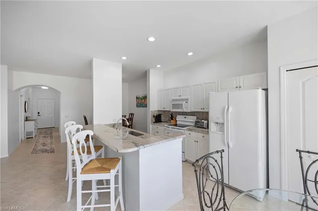 a kitchen with stainless steel appliances granite countertop a refrigerator and a stove top oven